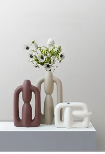 Close-up of modern abstract ceramic vases with matte finish and hollow ring design
