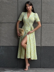 Detail of floral wrap dress featuring a V-neckline and waist tie on light yellow fabric