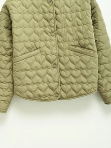Detailed view of heart-shaped quilting and side pockets on a sage green jacket