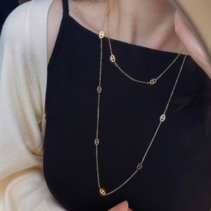 Detail view of 18K gold plated safety pin necklace showing the oval pig nose buckle links