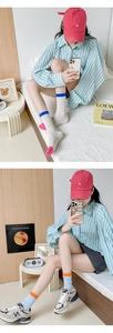 Gros plan de chaussettes en maille color-block montrant des motifs ajourés et du coton doux