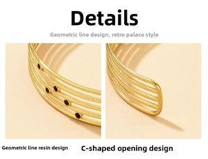 Détail d'un bracelet ouvert doré aux lignes géométriques et accents d'huile noire