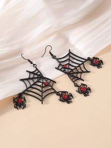Detail of Halloween spider web earrings with red rhinestones on a white textured backdrop
