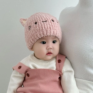 Detailansicht einer rosa Plüschmütze für Babys mit süßen Katzenohren und Stickerei.