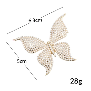 Golden butterfly hair clip with sparkling rhinestones and pearls on white background