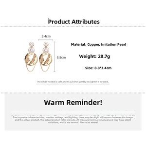 Detail of gold-plated earrings with three white faux pearls and wavy metal discs