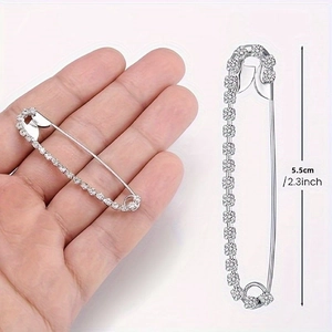 Détail d'une épingle de sûreté argentée de 5,5 cm avec strass et indication de taille