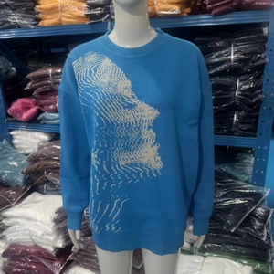 Dettaglio del maglione in maglia blu con motivo jacquard bianco di Cupido e texture