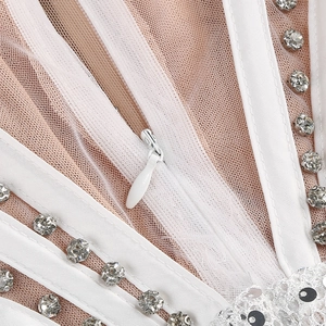 Detail of white mesh dress featuring sequin lace, rhinestone patterns and invisible zipper