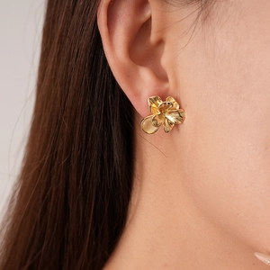 Detailansicht der goldenen Blumenohrstecker am Model für einen trendigen französischen Stil