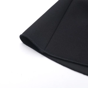 Détail du tissu tricoté noir avec coutures renforcées sur une robe de soirée ajustée chic
