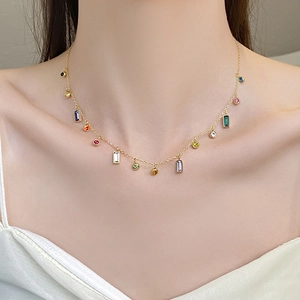 Collana minimalista in titanio dorato con pendenti in zircone colorato sul collo