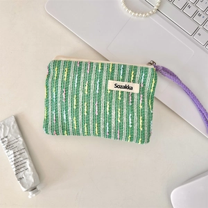 Makroansicht der grünen Strick-Kosmetiktasche mit bunten Punkten und lila Schlüsselband