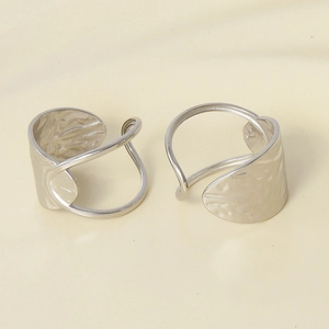 Detailed macro view of irregular hammered silver-colored rings with open adjustable design