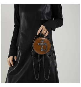 Detail view of brown PU leather round crossbody bag with metal cross and chain tassels