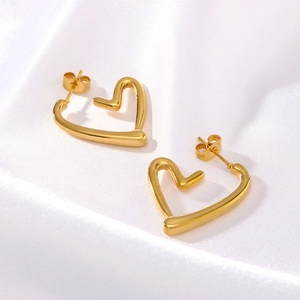 Elegant 18K gold-plated hollow heart earrings on white silk fabric for women