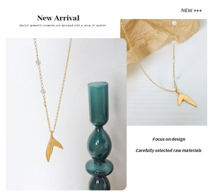 Detailed view of elegant gold plated mermaid tail pendant necklace with white pearls