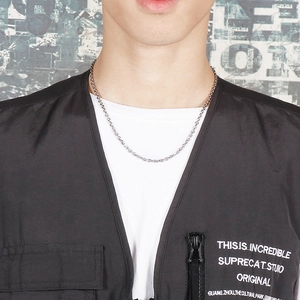 Detail of a minimalist silver stainless steel O-link chain necklace worn by a model