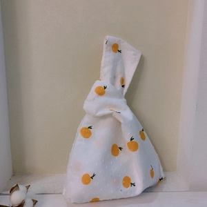 Detail view of Japanese style wrist bag featuring orange patterns and textured dots