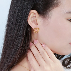 Vue rapprochée de boucles d'oreilles minimalistes en forme de cœur doré évidé