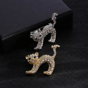 Detailed view of cat-shaped alloy brooches with sparkling rhinestones in gold and silver