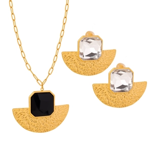 Chic gold fan-shaped necklace and earrings set with black glass stone on white background