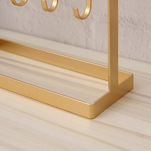 Golden iron jewelry display stand featuring a minimalist rectangular metal base