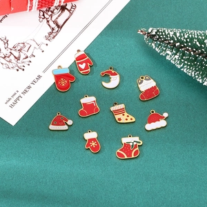 Close-up of festive Christmas alloy charms including Santa, socks and hats on green background