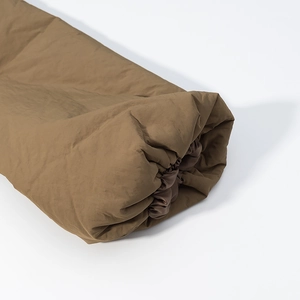 Detail of elastic cuff on dark khaki padded coat showing fabric texture and stitching