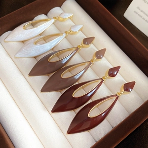 Detail view of colorful oil-dripped hollow water drop earrings in a velvet jewelry box