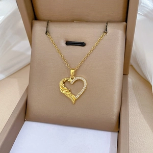 Macro shot of gold heart necklace with asymmetric diamonds and display gift box