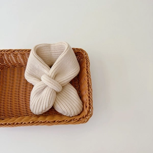 Close-up of beige knitted baby neck warmer, soft wool material, perfect autumn winter detail.