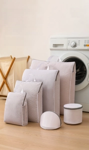 Set of mesh laundry bags with honeycomb texture and gray zippers for garment protection