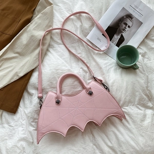 Close-up of pink bat-shaped handbag featuring spiderweb stitching and silver hardware