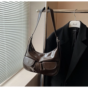 Detail of dark brown vintage hobo bag featuring polished leather and front pockets
