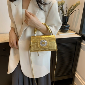 Elegant gold crocodile pattern handbag with luxury square crystal buckle shown on model