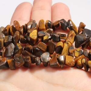 Macro shot of natural tiger eye irregular gemstone beads showing golden brown texture