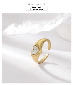 Detail of gold heart ring with mother of pearl shell inlay and matte steel texture