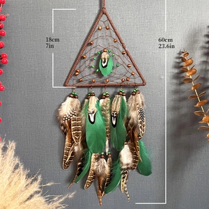 Triangle dream catcher with brown frame, natural feathers and wooden beads on grey wall
