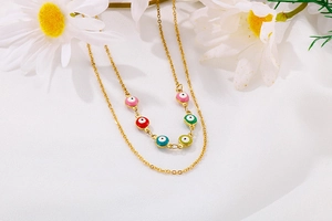 Detail of layered gold O-chain necklace with colorful enamel Evil Eye charms on silk