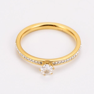 Detailed view of a gold six-prong ring with a large zircon and pavé diamond band