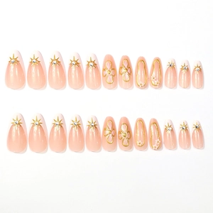 Pink long almond press-on nails with golden 3D flowers and star patterns