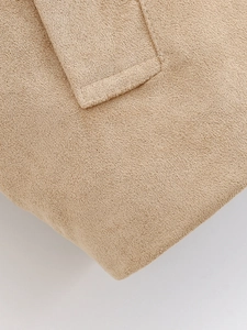 Close-up of soft camel suede texture and high-quality stitching on the jacket collar