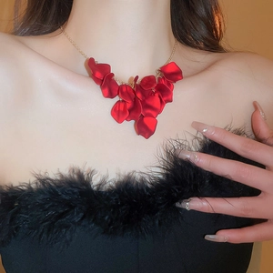Close-up of elegant red petal tassel necklace worn by a model for a chic vacation look