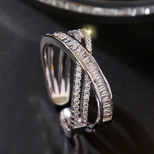 Crossed geometric open ring with baguette and round cut micro-pave crystals