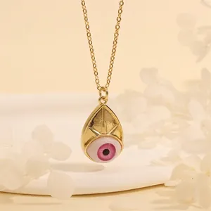 Detail of 18K gold-plated necklace with a teardrop evil eye pendant and pink iris