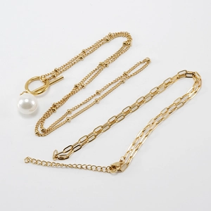 Détail du collier double avec chaîne trombone plaquée or 18K et pendentif perle blanche