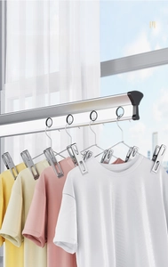Macro view of stainless steel clothes pegs showing windproof clips on a laundry drying rack