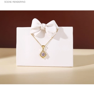 Macro shot of gold heart and leaf pendant necklace with crystals on white display stand