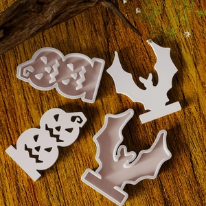 Detail view of 4-piece Halloween bat and pumpkin silicone molds on a rustic wooden table